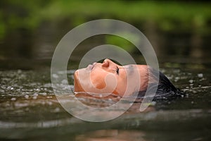 Boy swimming in the cannal near the Damnoen Saduak Floating Market