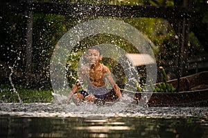 Boy swimming in the cannal near the Damnoen Saduak Floating Market