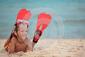 Boy with swimming fins on beach photo
