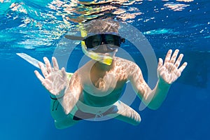 Boy in swimming mask dive in Red sea near yacht