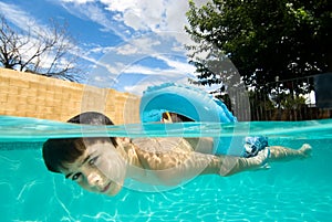 Boy swimming in pool with float ring