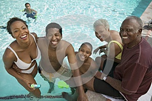 Boy (7-9) at swimming pool with parents and grandparents elevated view portrait. photo