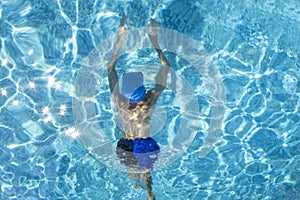 The Boy Swims Underwater in the Pool. An Athlete in Swimming Goggles is Preparing for a Swimming Competition in the Pool. Outdoors
