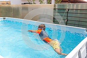 Boy in swimwear diving into pool during swimming practice
