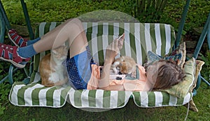 Boy in a Swing with Cats and Phone