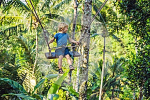 A boy on a swing over the jungle, Bali