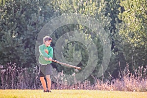 Boy Swinging a Large Stick Like a Baseball Bat