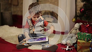 Boy with tablet PC near christmas tree