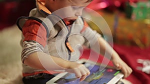 Boy with tablet PC near christmas tree