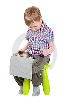 Boy with a Tablet PC sitting on a chair
