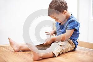 Boy, tablet and typing with games, kid and internet with network, connection and home. Child development, apartment and