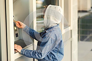 Boy takes money in cash dispenser for alien card. Boy takes cash at ATM machine