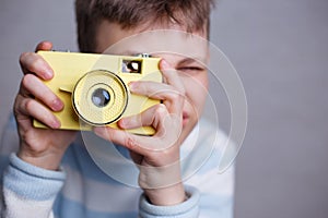 Boy taking a picture with vintage camera. Photography, hobby and