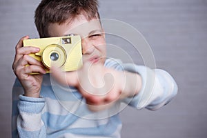 Boy taking a picture with vintage camera pointing on you. Photog