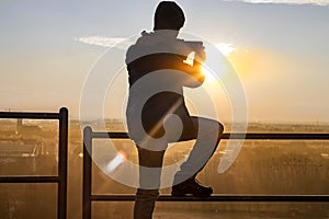 Boy taking pictures to a sunset
