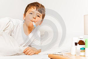 Boy taking temperature with electronic thermometer