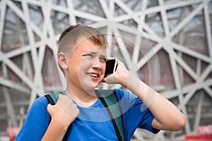 Boy talking on cell phone in the Olympic Park in Beijing
