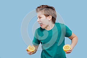 Boy taste a fresh lemon, sour taste, make grimace,