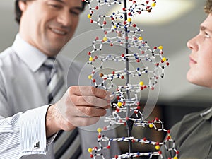 Boy With Teacher Examining DNA Model