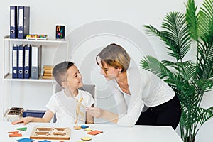 A boy with a teacher learns develops in the psychologist's office