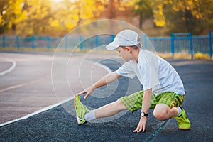 Boy Teen doing sports exercises on a stadium