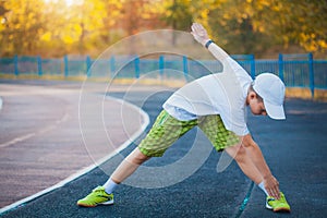 Boy Teen doing sports exercises on a stadium