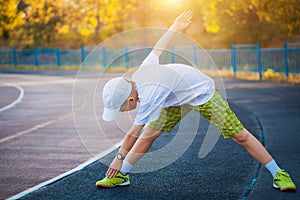 Boy Teen doing sports exercises on a stadium