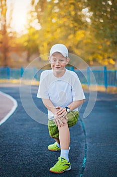 Boy Teen doing sports exercises on a stadium