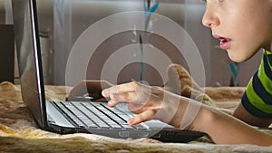 Boy teen laptop browsing internet play lying in bed