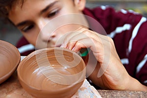 Boy teen potter clay bowl working