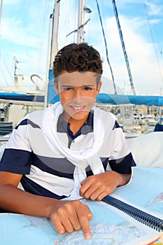 Boy teen sailorsitting on marina boat chart map