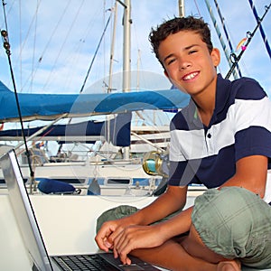 Boy teen seat on boat marina laptop computer