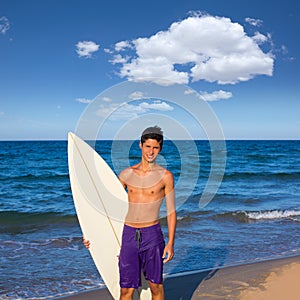 Boy teen surfer happy holing surfboard on the beach
