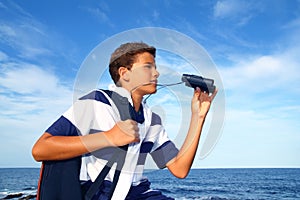 Boy teenager binoculars explorer in blue beach