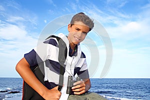 Boy teenager binoculars explorer in blue beach