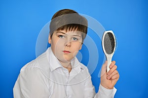 Boy teenager with comb in his hand photo