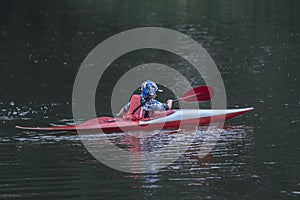 Boy teenager manages a canoe kayak on a wide river.