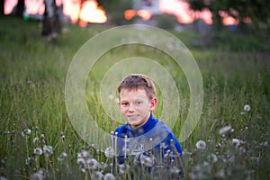 Boy teenager on a red sunset background.