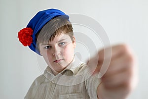 Boy teenager in Russian national cap with cloves showing a fist photo