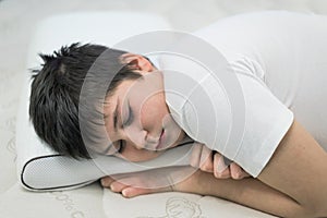 Boy teenager sleeping face down on anatomic pillow