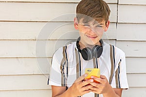 Boy teenager teen male child using cell phone and headphones