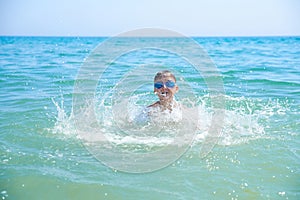 BOY TEENAGERS IN WATER GOGGLES SWIM IN THE SEA