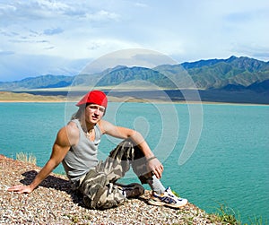 Boy teens sitting by a beautiful lake