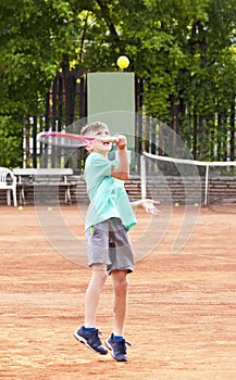 A boy on the tennis court. Kids tennis. Professional children`s tennis sports. Sports anger, the will to win