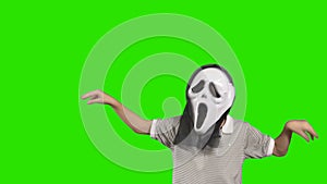 Boy in terrible mask scary at green background