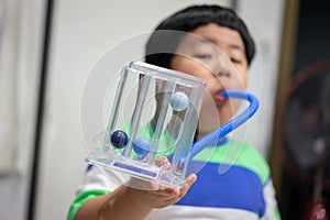 A boy is testing and administering lungs with a tri-ball dryer