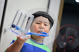 A boy is testing and administering lungs with a tri-ball dryer