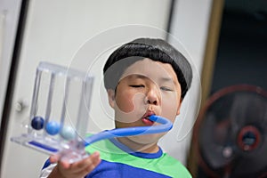 A boy is testing and administering lungs with a tri-ball dryer
