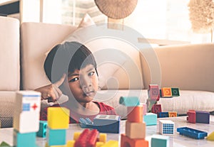 Boy thinking thoughful creating toy block