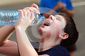A boy thirsty eagerly drinking water